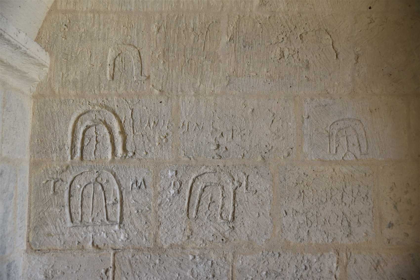 Gros plan des graffiti médiévaux. A droite la représentation d'une église