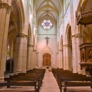 La nef et la chaire à prêcher vus depuis le transept. Sur la cuve sont sculptés...