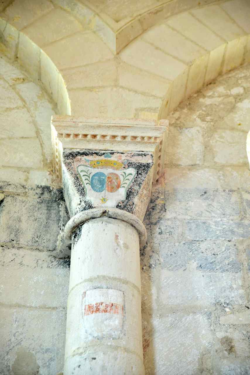 Chapiteau peint et un blason sur la colonne