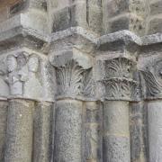 Colonnes à chapiteaux sculptés à droite du portail érodés par le temps