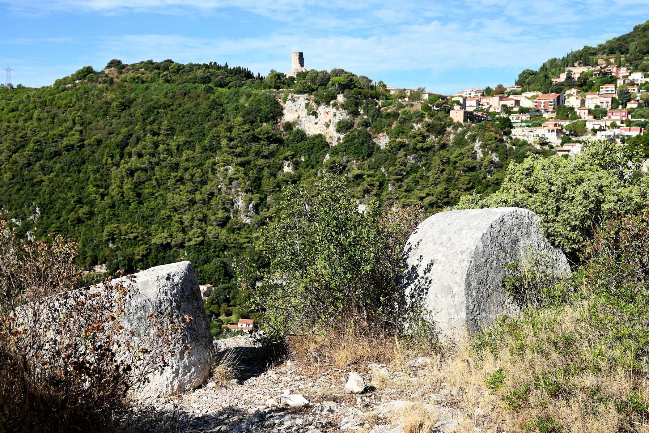 En avant-plan d'anciens blocs taillés  A l'arrière-plan le trophée d'Auguste et la Turbie