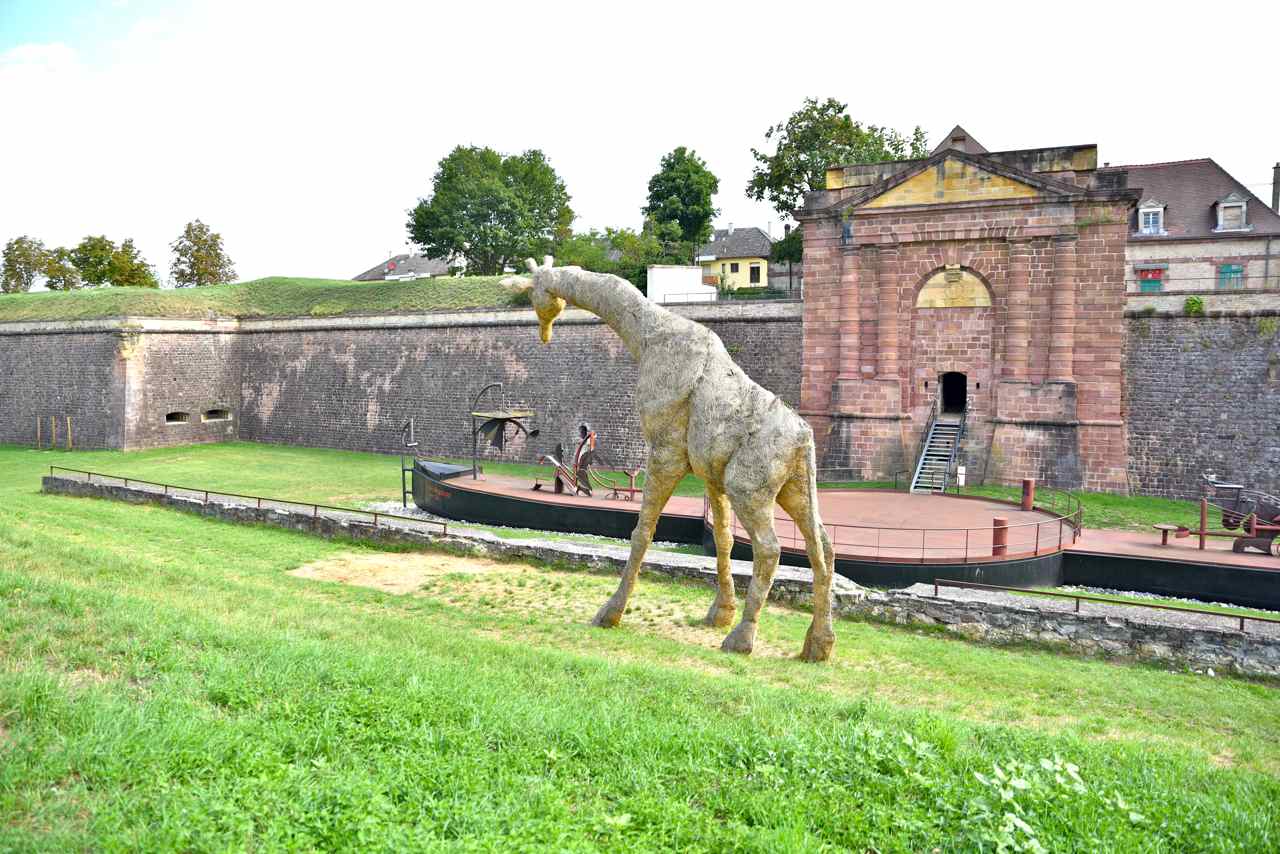 Entre la girafe, et  la porte de Belfort, le bateau symbolise ...