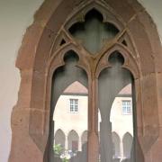 Le cloître se mire dans la fenêtre gothique de la salle capitulaire.