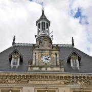 Gros plan sur la toiture, l'horloge et le clocheton