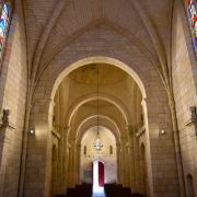 La nef vue depuis l'abside éclairée par des vitraux...