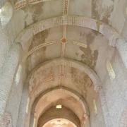 La voûte centrale, ornée de vestiges de fresques, est en berceau sur doubleaux.
