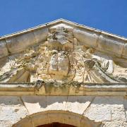 Le blason du fronton érodé par les vents marins.