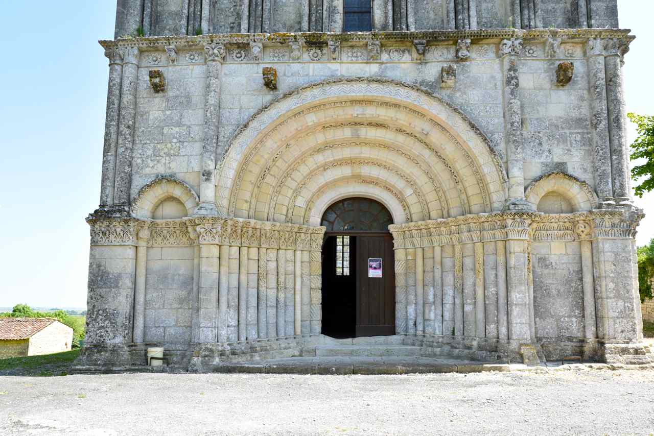 Le portail à six voussures est encadré par deux portes aveugles