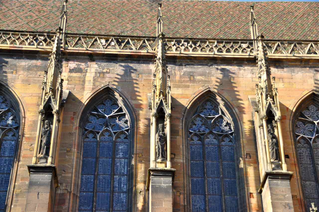 Le toit côté nord de la nef, ses tuiles vernissées et trois  niches à sculptures