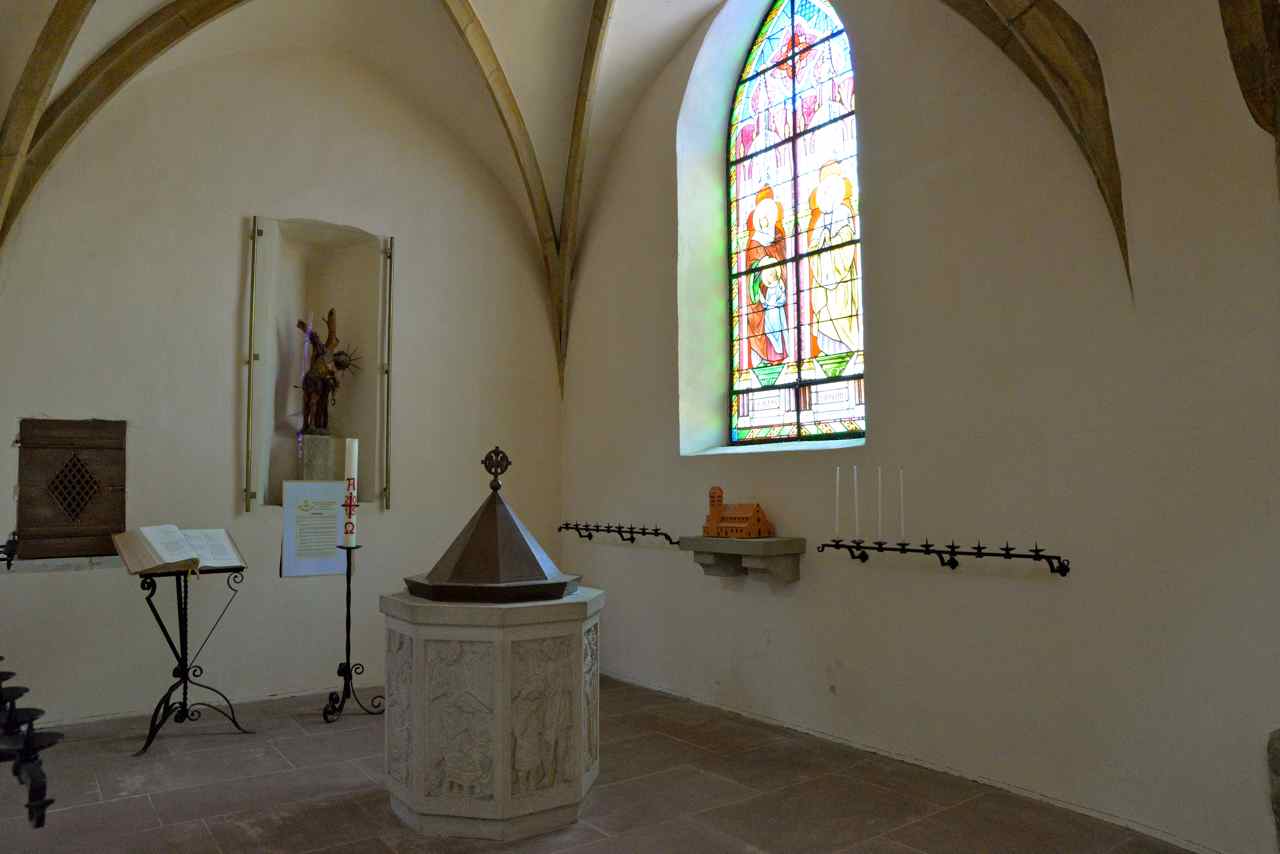 Les fonts baptismaux éclairés par le vitrail de St Augustin et St Jérôme
