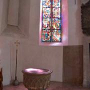 Les fonts baptismaux et le vitrail de la chapelle sud