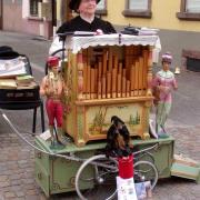 On aperçoit les tuyaux en bois de l'orgue de Barbarie