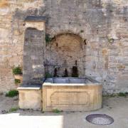 Une fontaine adossée à la muraille de la ville