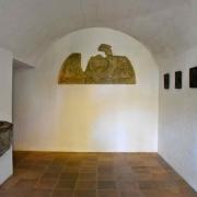 Vestibule d'accès à l'église avec un bas-relief et le début du Chemin de Coix